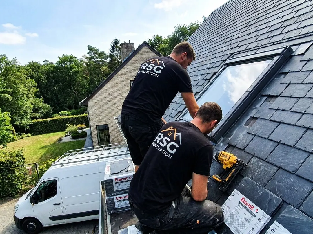 Couvreurs RSG Rénovation fixant des ardoises autour d'une fenêtre de toit